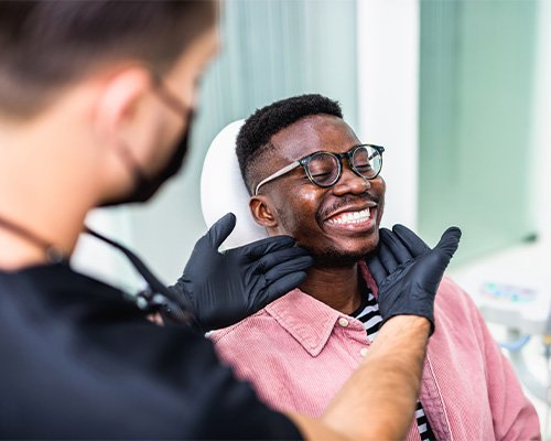 Dentist looking at smiling patient's teeth